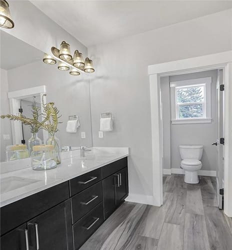 New vanity and wooden flooring installed inside a guest bathroom
